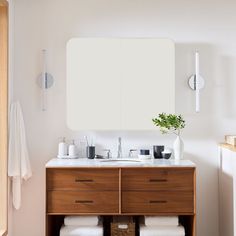 a bathroom vanity with two drawers and a mirror above it, in front of a radiator