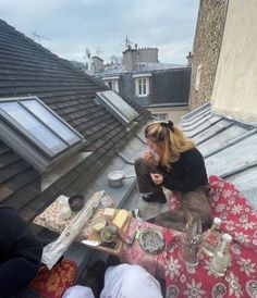 a woman sitting on top of a roof eating food