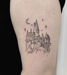 a woman's thigh with a castle tattoo on it