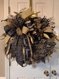 a blue and gold christmas wreath hanging on the front door for someone's house