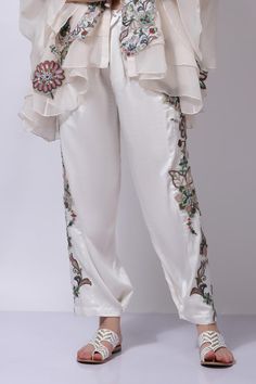 Ivory white floral embroidered jacket. Paired with an inner and embroidered pant.
Components: 3
Pattern: Embroidered
Type Of Work: Chikankari
Neckline: V Neck
Sleeve Type: Flared
Fabric: 25% Silk, 75% Cotton
Color: Ivory,White
Other Details: 
Attached cotton lining
Model Height: 5 ft 7 inches, wearing size M
Closure: Zip
Occasion: Resort - Aza Fashions Elegant Pant Set With Intricate Embroidery For Spring, White Pant Set With Resham Embroidery For Wedding, Elegant White Pant Set With Resham Embroidery, Elegant Spring Pant Set With Intricate Embroidery, Spring Designer Sets With Pearl Embroidery, Festive Off-white Set With Floral Embroidery, Festive Off White Sets With Floral Embroidery, Spring Wedding Pant Set With Intricate Embroidery, Festive Off-white Sets With Floral Embroidery