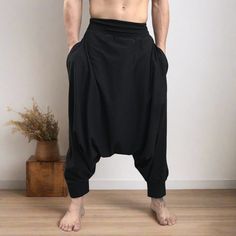 A pair of mens harem pants in black soft, lightweight stretch cotton.  Wear these handmade drop crotch pants to a festival, yoga, or as your new favorite lounge pants around the house. Pair with our men's kimono in black for a loose, flowing monochrome look!  Materials: black color 95% cotton 5% spandex. Very soft, light weight and flowing. This is a high frequency wear garment meaning handmade with intention, perfect for meditation or spiritual practices.  Measurements:  Fits: S, M, M/L -Length Yoga Harem Pants With Drop Crotch, Relaxed Fit Drop Crotch Harem Pants For Yoga, Yoga Harem Pants With Drop Crotch And Relaxed Fit, Black Harem Yoga Pants With Pockets, Baggy Yoga Pants With Drop Crotch, Black Cotton Harem Yoga Pants, Black Cotton Harem Pants For Yoga, Baggy Harem Yoga Pants, Baggy Drop Crotch Harem Pants For Yoga