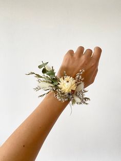 a woman's arm with flowers and leaves on it, against a white background