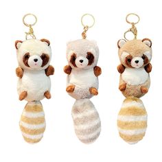 three stuffed animals are hanging from key chains