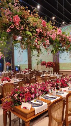 the tables are set with place settings and flowers hanging from the ceiling, along with plates and napkins