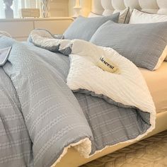 an unmade bed with blue and white comforters