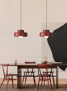 a dining room table with chairs and a painting on the wall in the back ground