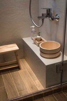 a wooden bowl sitting on top of a counter next to a shower