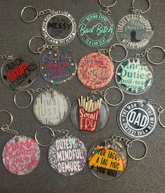 a bunch of key chains that have different designs on them, all in different colors