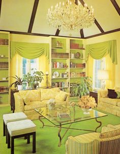 a living room filled with furniture and a chandelier above a glass top table