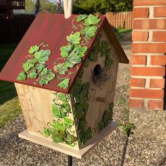 a bird house with green leaves painted on it