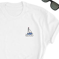 We have express delivery for our shirts! 📦⚡.  From cart to door in just 2-3 days, only for 3.5 USD extra.  You can find the express delivery option in the cart. Boat Icon Shirt, Cute Boat Tee Shirt, Boat Design Tee Top, Sailing Boat Lover T-Shirt, Boat Cute Gift Shirt, Boats Lover Friends UNISEX Tee Friends will love it! This t-shirt feels soft and lightweight, with the right amount of stretch. It's comfortable and flattering for both men and women.  * 100% cotton (heather colors contain polyester) * Fabric weight: 5 oz  * Shoulder-to-shoulder taping * Side-seamed Time for Delivery: * Processing & production time is 1-6 business days (usually 2-3 days). * U.S. Shipping time: 3-5 business days.  * International shipping time: 4-15 days. - Please note European customers: Some orders going t Boat Tshirt Design, White Nautical Short Sleeve Tops, White Nautical Crew Neck Top, White Nautical Short Sleeve T-shirt, White Short Sleeve Nautical T-shirt, White Nautical Style Short Sleeve T-shirt, Nautical Cotton T-shirt For Sailing, White Short Sleeve Nautical Shirt, White Nautical Cotton Shirt