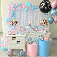 a baby shower party with balloons, cake and other items on the table in front of it