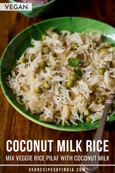 a green bowl filled with rice and peas next to a spoon on top of a wooden table