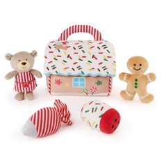 three stuffed animals are standing next to a small toy house with a door and window