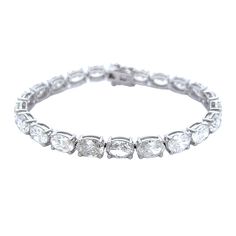 This 22.57 CT's Oval Diamond Tennis Bracelet offers a luxurious diamond look. Its impressive 22.57 CTs and oval stones shimmer brilliantly, adding an extra level of elegance to any ensemble. This diamond tennis bracelet is the perfect statement piece for any occasion. DIAMOND 22.57 OV TCW 22 PCS. F H SI1-SI218K WG 17.38 GRAMS SIZE 7 BS-1696 Oval Link Diamond Tennis Bracelet With Diamond Accents, Diamond Tennis Bracelet With Oval Link And Accents, Oval Link Diamond Tennis Bracelet With Accents, White Gold Oval Tennis Bracelet With Prong Setting, Oval White Gold Tennis Bracelet With Prong Setting, Oval Cubic Zirconia Tennis Bracelet With Prong Setting, Diamond Oval Link Tennis Bracelet, Oval Diamond White Tennis Bracelet, White Gold Diamond Tennis Bracelet With Oval Links