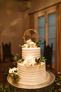 A 2 tier white frosted cake with a Mr. & Mrs. Le topper Engagement Cake Images, White Decor Wedding, Wedding Cake Two Tier, Wedding Cake Designs Elegant, Wedding Reception Cake, Wedding Cake Simple Elegant, White And Gold Wedding Cake, Anniversary Cake Designs, 50th Wedding Anniversary Cakes