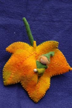 an orange and yellow flower on a blue cloth with a wooden bead in the center