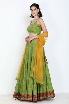 Green lehenga with floral embroidery, mirror work and sequin embroidery on the border. Comes with strappy blouse and yellow dupatta. Component: 3 Pattern: Embroidery Type Of Work: Thread and Mirror Neckline: Round Sleeve Type: Sleeveless Fabric: Pure Cotton Color: Green Other Details:  Dupatta with contrast border Tie up at the back Occasion: Wedding - Aza Fashions Pista Green Pre-draped Saree With Mirror Work For Navratri, Pista Green Choli With Gota Work In Traditional Drape, Pista Green Lehenga With Gota Work In Traditional Drape, Unstitched Pista Green Lehenga With Gota Work, Semi-stitched Pista Green Choli With Gota Work, Traditional Drape Pista Green Lehenga With Gota Work, Bollywood Style Choli In Pista Green With Gota Work, Embroidered Pista Green Pre-draped Saree For Navratri, Pista Green Choli With Gota Work For Diwali