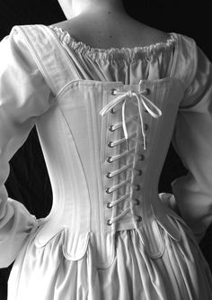 "This 18th century corset is rigidly boned with closely spaced 1/4\" steel bones and is cut to enhance and lift the bust, and shape the waist. The additional lacing up the center front allows for increased adjustment. The waist tabs, cut in one with the corset, curve and smooth over the hips. The over the shoulder straps adjust with a front tie and are basted in at the back. The straps are easily removable. Strapless stays are one of the signature looks of this period. Features include: Ø Side s Elegant Corset Dress With Boning For Costume, Historical Underbust Corset With Fitted Bodice, Historical Underbust Corset For Wedding, Elegant Costume Corset With Boning, Medieval Underbust Corset Belt, Historical Wedding Corset With Boned Bodice, Elegant Boned Corset For Costume, Elegant Boning Corset For Costume, Victorian Corset With Historical Design