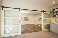 an empty room with sliding glass doors leading into the kitchen