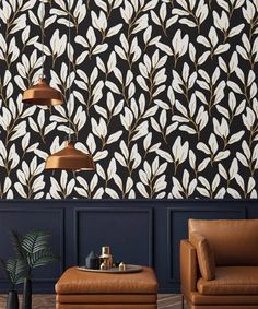 a living room with two leather chairs and a coffee table in front of the wall