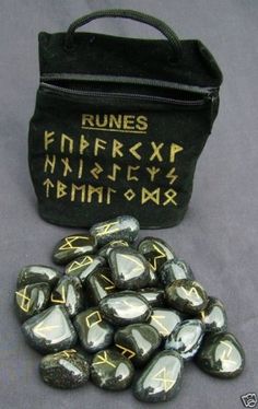 some rocks are next to a black bag with writing on it and an embroidered pouch