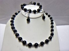 Beaded necklace, bracelet and earring set. The necklace measures approx. 18-1/2 inches long. The bracelet measures 7-1/2 inches long. The earrings measure just under 2 inches long. Round black beads, fluted silver tone spacer beads and clear faceted crystal beads. Add them to your jewelry wardrobe. Pre owned. In good condition. All sales are final and as is. Thank you for looking. You may also love this: https://www.etsy.com/listing/625416058/marvella-black-beaded-necklace-vintage?ga_search_quer Black Round Beads Jewelry Set As Gift, Black Round Beads Jewelry Set For Gift, Black Round Beads Costume Jewelry, Black Jewelry Set With Round Beads For Gift, Black Jewelry Set With Round Beads As A Gift, Black Costume Jewelry Sets As A Gift, Black Costume Jewelry Sets For Gift, Bracelet And Earring Set, Jewelry Wardrobe