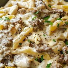 a close up of a plate of pasta with meat and cheese on it's surface