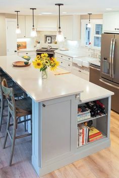 a kitchen with an island, sink and refrigerator in it's center area is shown