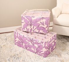 two pink storage boxes sitting on top of a rug