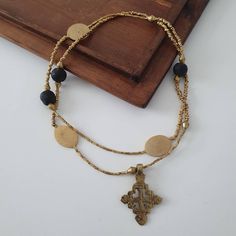 This long statement  necklace is handmade using Ghanaian glass beads, an Ethiopian Coptic Cross ,Ethiopian pendants and an brass metal  beads. The Brass Metal beads is made from Ethiopian recycled Bullets that was hand formed by rural farmers. Ghana Beads, Ethiopian Cross, Coptic Cross, Krobo Beads, Long Statement Necklace, Necklace Leather, Beaded Cross, Brass Metal, Metal Beads