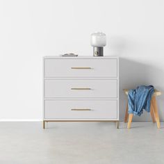 a white chest of drawers next to a blue blanket