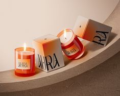 three candles sitting next to each other on top of a wall with the word aruh written on them