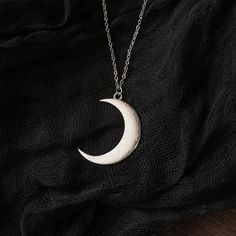 Channel your inner mystic with our enchanting large crescent moon necklace! Crafted with intricate detailing and a touch of magic, this witchy accessory is perfect for those who embrace the mystical and the mysterious. Made to stand out, the large crescent moon pendant exudes a captivating allure, drawing attention with its bewitching presence. Whether you're casting spells under the moonlight or simply adding a touch of cosmic charm to your everyday ensemble, this necklace is sure to make a sta Space Themed Necklace, Bohemian Crescent Metal Necklaces, Moon Phase Metal Necklace In Moon Shape, Moon Phase Necklace In Metal, Metal Moon Phase Necklace, Bohemian Crescent Moon Charm Necklace, Gothic Moon Charm Round Pendant Necklace, Silver Moon Shaped Witchy Jewelry, Mystical Moon Phase Necklace