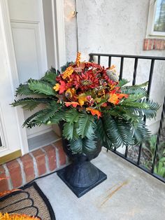 a vase filled with flowers sitting on top of a porch