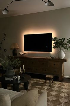 a living room filled with furniture and a flat screen tv mounted to the side of a wall