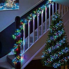 a christmas tree is lit up on the stairs