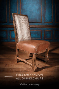 a brown leather chair sitting on top of a wooden floor next to a blue wall