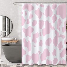 a bathroom with a pink and white shower curtain in the shape of a cow print