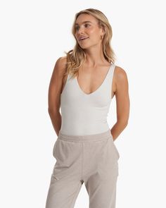 Ultra-soft and oh-so-wearable, the Halo Bodysuit has a clean plunge neckline, lightly supportive built-in shelf bra and a no-show thong cut. Whether you're heading to yoga or catching your next flight, this layer is made with our mostly recycled DreamKnit™ premium stretch fabric that wicks away moisture, moves with you and looks good while doing it. Snap closure makes it effortlessly wearable. | Vuori Halo Bodysuit | Salt Heather | XXL Vuori makes premium performance apparel inspired by the acti Trendy Tank Tops, Slim Tank Top, Plunge Bodysuit, Plunge Neckline, White Bodysuit, Heather White, Performance Outfit, Shelf Bra, Wide Leg Jumpsuit