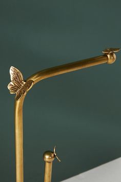 a gold colored sink faucet with two handles and a butterfly on the handle