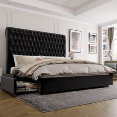 a bed with a black headboard sitting on top of a wooden floor