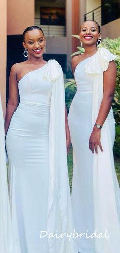 two women in white dresses standing next to each other