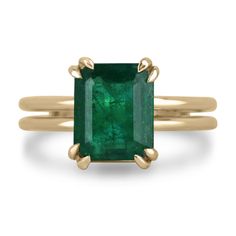 This 3.28 carat natural Zambian emerald is a true statement piece. The deep, dark green color of the stone is absolutely breathtaking and is sure to draw attention. The emerald is set in a simple four-prong setting with double claw prongs, which ensures that the stone is securely held in place. The split shank of the ring is made in 18k yellow gold, which complements the rich green of the emerald perfectly. The split shank adds a modern touch to the classic four-prong setting, making the ring both timeless and contemporary. Setting Style: Prong - Solitaire Setting Material: 18K Yellow Gold Setting Weight: 7.2 Grams Main Stone: Emerald Shape: Emerald Cut  Weight: 3.28-Carats Clarity: Semi-Transparent Color: Deep Dark Green Luster: Good Treatments: Natural, Oiling Origin: Zambia Estimated Re East West Engagement Ring Emerald, Colombian Emerald Ring, Emerald Set, Prong Engagement Rings, Emerald Cut Rings, Claw Prong, Zambian Emerald, Hand Ring, Colombian Emeralds