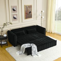 a black couch sitting on top of a white rug