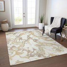 a living room area with a chair and rug on the hardwood floor next to a door