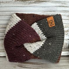 two crocheted hats sitting on top of each other in front of a wooden background