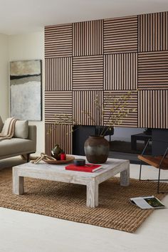 a living room with a couch, coffee table and wall art on the back wall