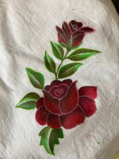 a white cloth with red flowers painted on it